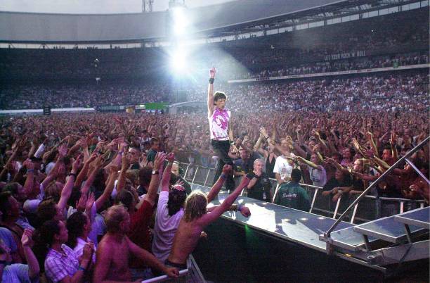 11th AUGUST: Mick Jagger from The Rolling Stones performs live on stage walking down gantry in arena/stadium with crowds/audience surrounding him...