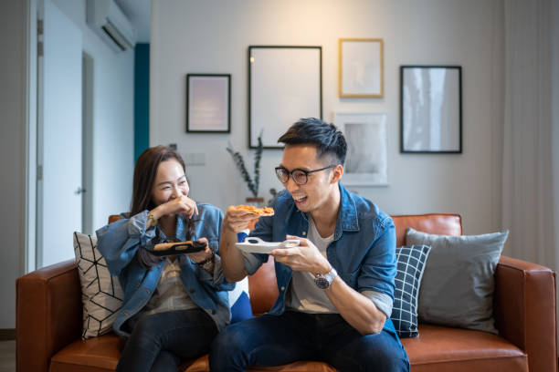 4 friends gathering at home for a quick meal - junk food stock pictures, royalty-free photos & images