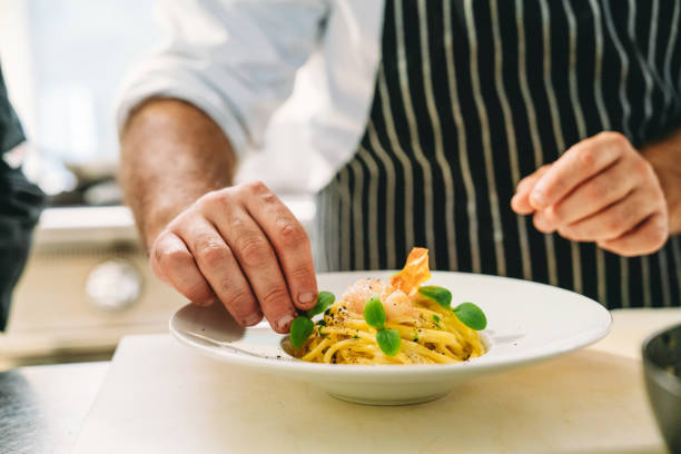 a chef is plating spaghetti - food stock pictures, royalty-free photos & images