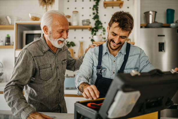 a dedicated male carpenter adeptly works on the installation and repair of kitchen components in a senior gentleman's residence, showcasing professionalism and expertise - home decoration stock pictures, royalty-free photos &