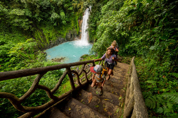a family hiking at rio celeste waterfall in costa rica. - travel stock pictures, royalty-free photos & images