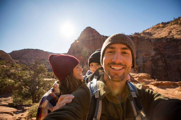 a family taking a selfie while hiking a scenic trail - travel stock-fotos und bilder