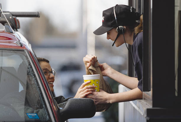 a fast-food employee gives a customer her order - food photos et images de collection