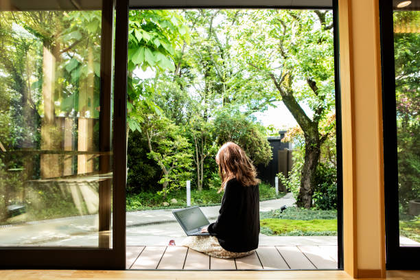 a female guest working on the porch of the guesthouse where she stayed during her trip to japan. - travel stock pictures, royalty-free photos & images
