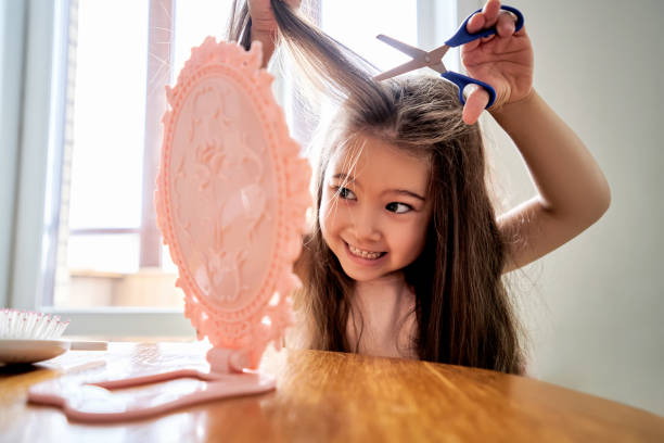 a girl about 6 years old cuts off her hair. - hairstyle stock pictures, royalty-free photos & images