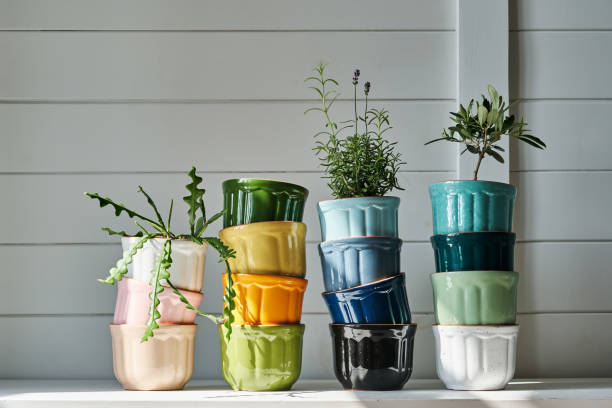a group of multicolored ceramic planters stacked on the dresser. - garden decoration stock pictures, royalty-free photos & images