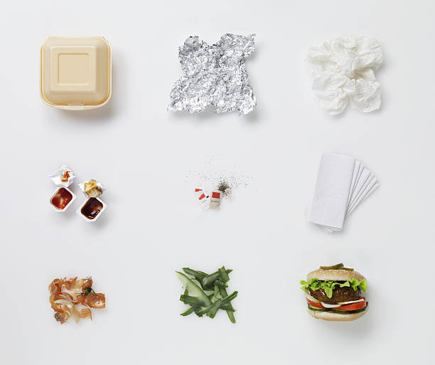 a hamburger aligned with all its associated waste - junk food stock pictures, royalty-free photos & images
