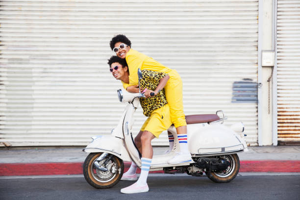 a hip young couple on a scooter - travel stock pictures, royalty-free photos & images