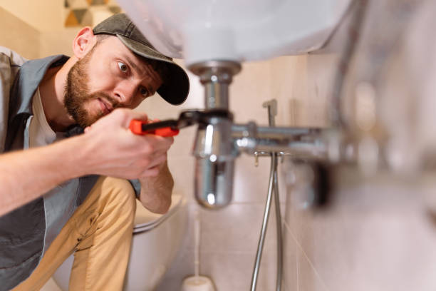 a plumber carefully fixes a leak in a sink using a wrench - home decoration stock pictures, royalty-free photos & images