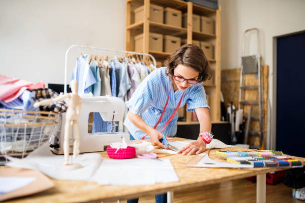 a portrait of young creative woman indoors making old clothes new and trendy. - fashion stock pictures, royalty-free photos & images