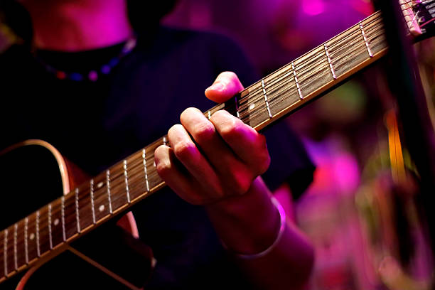 a professional male artist plays a rock guitar, the hand of a musician plays rock music. studio neon light. - concert stock pictures, royalty-free photos & images