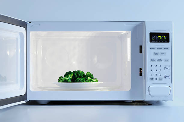 a small plate of broccoli inside a microwave - food stock pictures, royalty-free photos & images