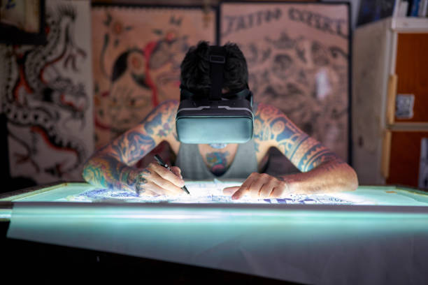 a tattoo artist in the studio design uses virtual reality glasses to draw a tattoo and see the colors how they will look - fashion stock pictures, royalty-free photos & images