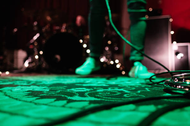 a unrecognizable musician standing on stage at a microphone during a show. blurred image. - concert stock pictures, royalty-free photos & images