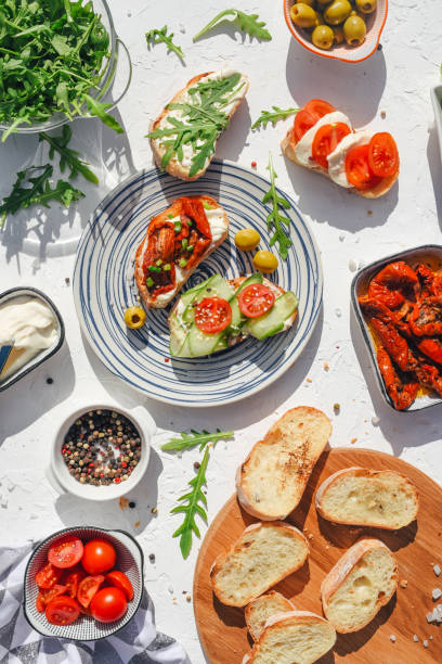 a variety of healthy toasts with vegetables, seeds and microgreens. colorful, plant-based vegan snacks. stylish table setting and food. catering. food delivery. festive table. - food stock pictures, royalty-free photos & imag