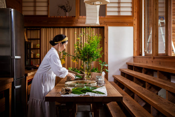 a woman cutting herbs and vegetables in the kitchen. - home decoration stock pictures, royalty-free photos & images