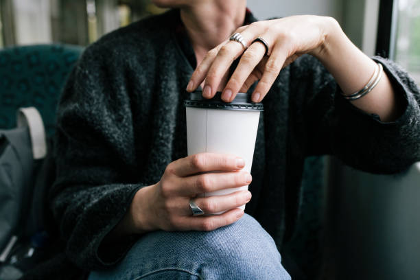 a woman holding a takeout coffee - junk food stock pictures, royalty-free photos & images