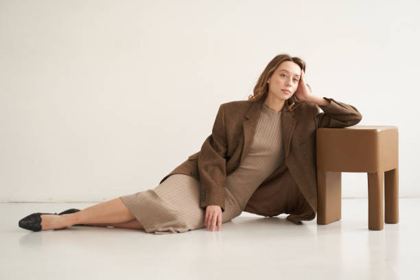 a woman in a brown jacket and beige dress. color of the year 2025. - fashion stock pictures, royalty-free photos & images