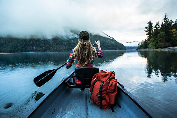 a woman in a canoe. - travel stock-fotos und bilder