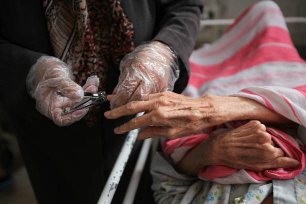 a woman is cutting nail of old woman - nails art stock pictures, royalty-free photos & images