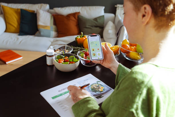 a woman is making a weekly nutrition plan and using mobile app - food stock pictures, royalty-free photos & images