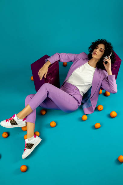 a woman listens to music on headphones - fashion stock pictures, royalty-free photos & images