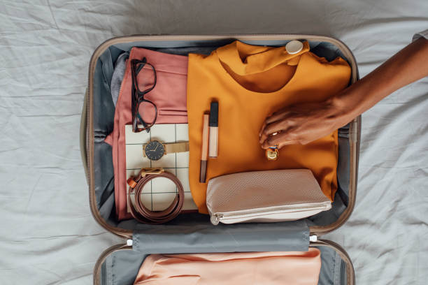 a woman packing her clothes in a suitcase - travel stock pictures, royalty-free photos & images