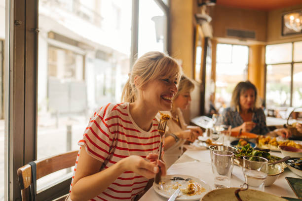 a young woman eating in a restaurant - food stock pictures, royalty-free photos & images