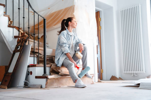 a young woman joyfully sits against the background of repairs in the house - home decoration stock pictures, royalty-free photos & images