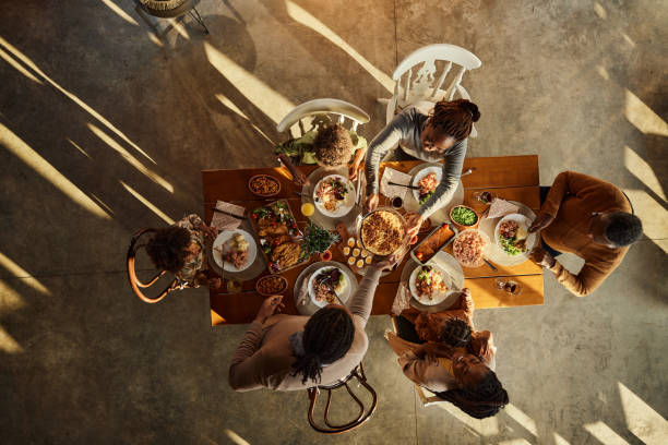 above view of black extended family having lunch at dining table. - food stock pictures, royalty-free photos & images