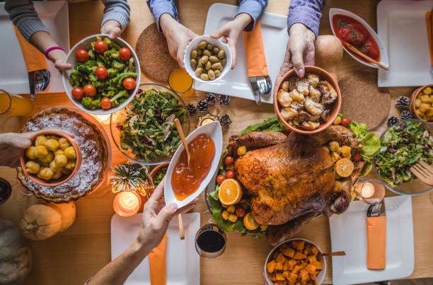 above view of passing food during thanksgiving dinner. - food stock pictures, royalty-free photos & images