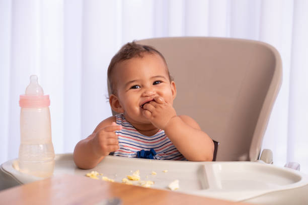 adorable baby eating food by himself. - food stock pictures, royalty-free photos & images