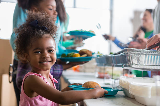 adorable little girl in soup kitchen - food stock pictures, royalty-free photos & images