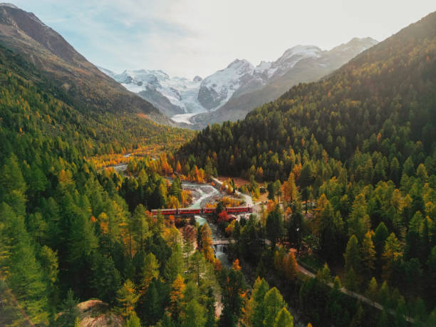 aerial view of train passing pristine landscape of piz bernina in swiss alps - travel stock pictures, royalty-free photos & images