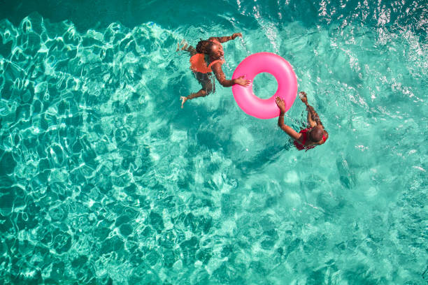 aerial view point of mother and daughter swimming together. - travel stock pictures, royalty-free photos & images