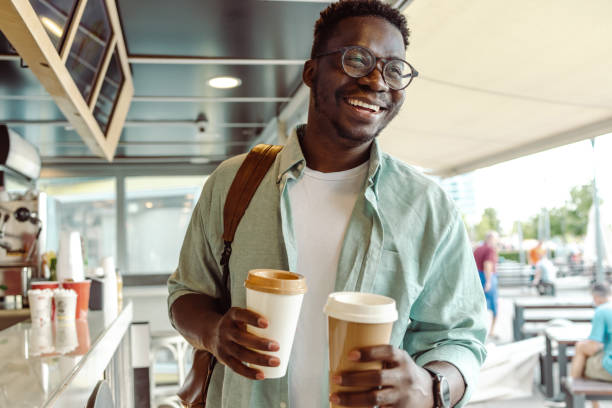 african-american student picking up a coffee - coffee stock pictures, royalty-free photos & images