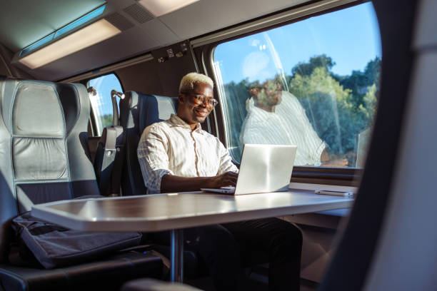 african american businessman working on laptop at the train - travel stock pictures, royalty-free photos & images