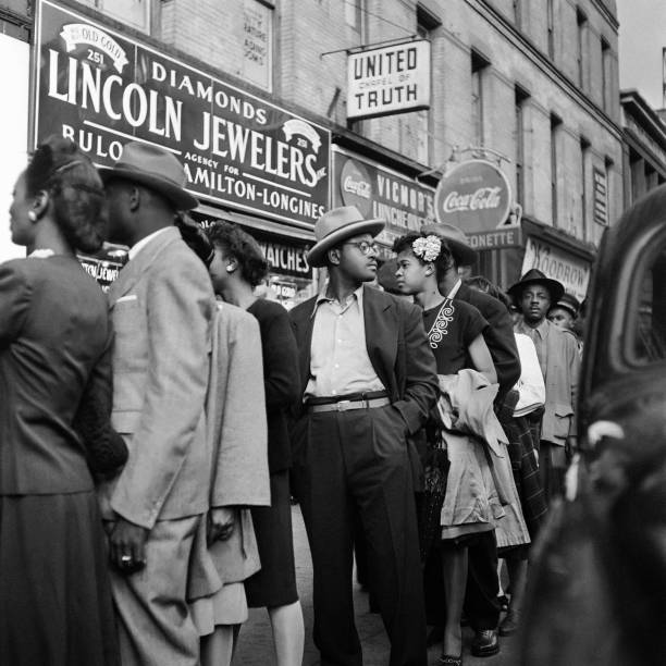 African American people wait in line at the entrance of a cabaret in October 1946 in Harlem, Manhattan, New York City.