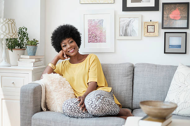 african american woman relaxing on sofa - fashion photos et images de collection