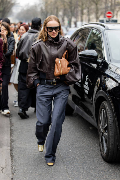 Alexandra Carl wears brown leather jacket, beige bag, grey pants outside Miu Miu during the Womenswear Fall/Winter 2025/2026 as part of Paris Fashion...