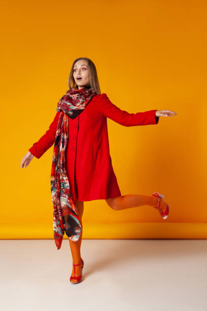 amazed woman in stylish outerwear walking in studio - fashion stock pictures, royalty-free photos & images