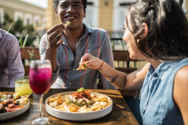 amis mangeant du guacamole dans un restaurant - food photos et images de collection