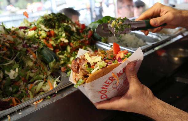 An employee prepares a customer's order at Mustafas Gemüse Kebap on July 06, 2022 in Berlin, Germany. The döner kebab, a fast food sandwich made of...
