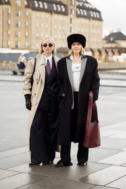 Anna Katinka von der Fehr wears black suit, white shirt red and blue tie, black leather gloves and beige long trench coat and Cathrine Leth Damgaard...