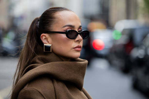 Anna Wein wears brown coat, earrings, sunglasses outside Sacai during Womenswear Spring/Summer 2025 as part of Paris Fashion Week on September 30,...