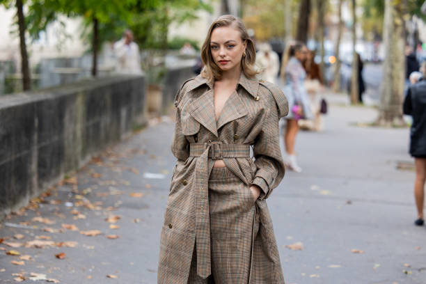 Anouchka Gauthier wears brown belted checkered coat, shorts outside Zimmermann during Womenswear Spring/Summer 2025 as part of Paris Fashion Week on...