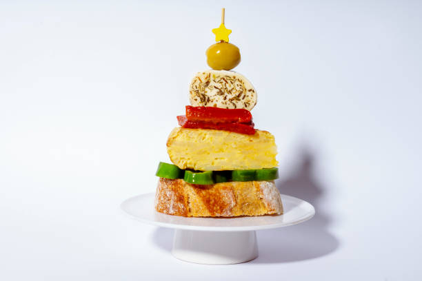 appetizer or tapa in the shape of a christmas tree made of bread, omelette, green pepper, red pepper, cheese and olive - home decoration stock pictures, royalty-free photos & images