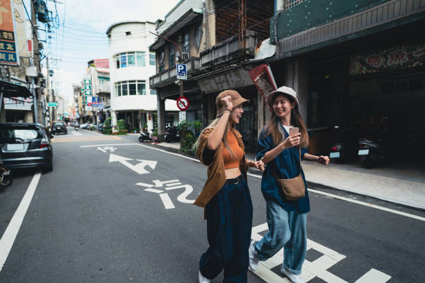 asia, two young women walk relaxed on the street in taiwan. - fashion stock pictures, royalty-free photos & images