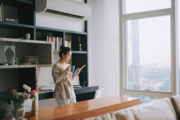 asian chinese beautiful woman enjoying her afternoon tea at living room looking outside window relax leaning on table - home decoration stock pictures, royalty-free photos & images