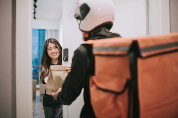 asian chinese delivery man with helmet press door bell for grocery food delivery - junk food stock pictures, royalty-free photos & images